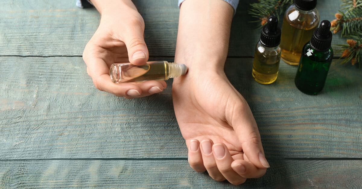 Essential oil roll on, women applying roll-on onto wrist