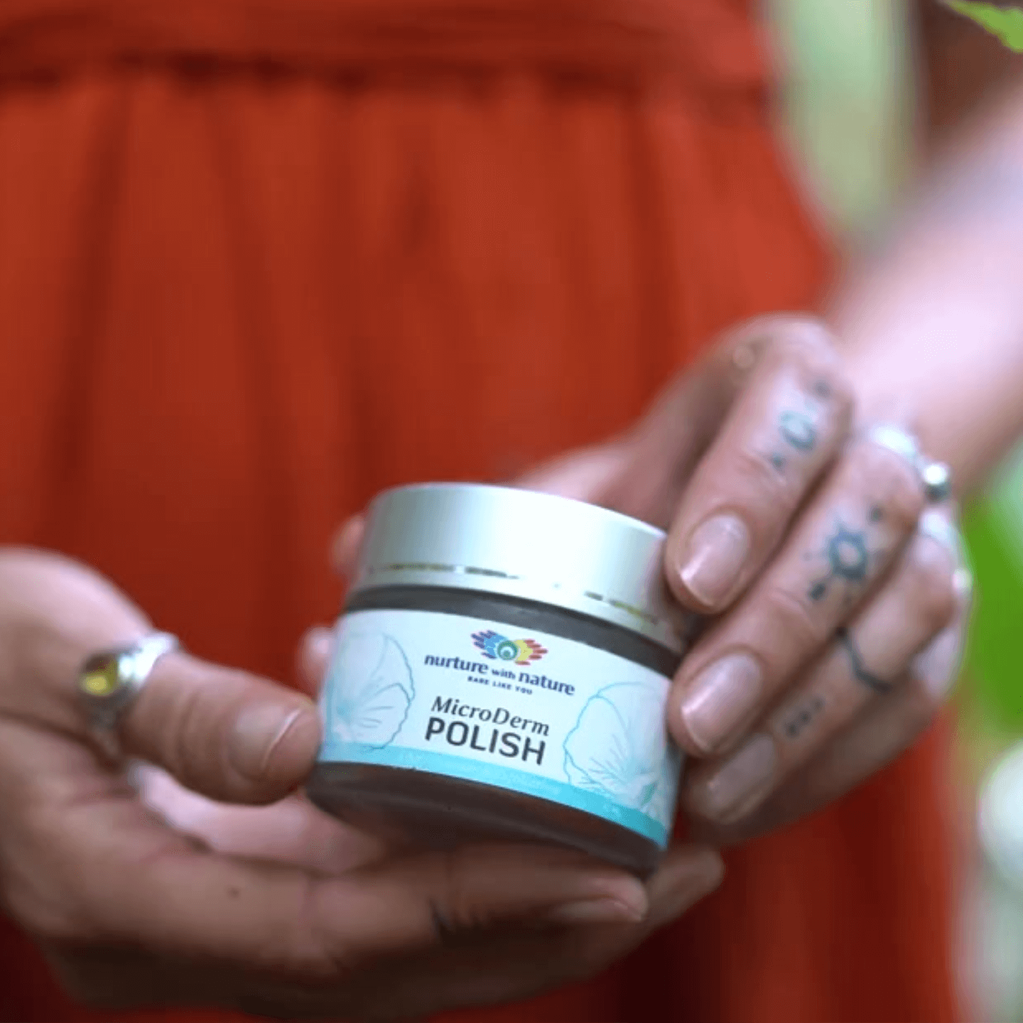 Person holding a jar of 'MicroDerm Polish' face cleanser